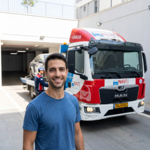 נהג רגוע ליד רכבו לאחר חילוץ רכב מחניון תת קרקעי על ידי נתי שירותי דרך בכל הארץ.