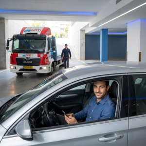 נהג רגוע ברכבו לאחר חילוץ רכב מחניון תת קרקעי בטוח ומהיר בכל הארץ על ידי נתי שירותי דרך.
