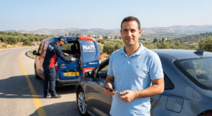 נהג רגוע ליד רכבו לאחר קבלת שירותי דרך ביטוח הראל נתי בכל הארץ.